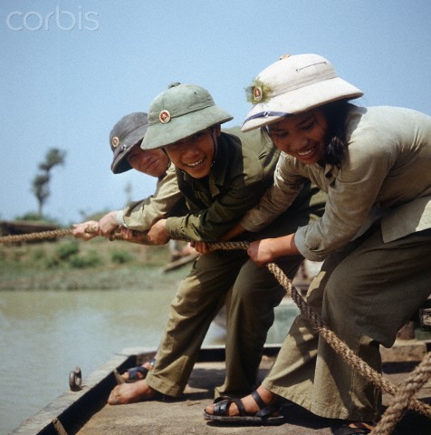 Miền Bắc 1973. Một nữ du kích cùng các anh bộ đội Cụ Hồ đang tham gia vào việc lắp ráp những chiếc cầu tạm phục vụ cho quân đội tại một vùng gần Đồng Hới, Quảng Bình. Ảnh. Werner Schulze.